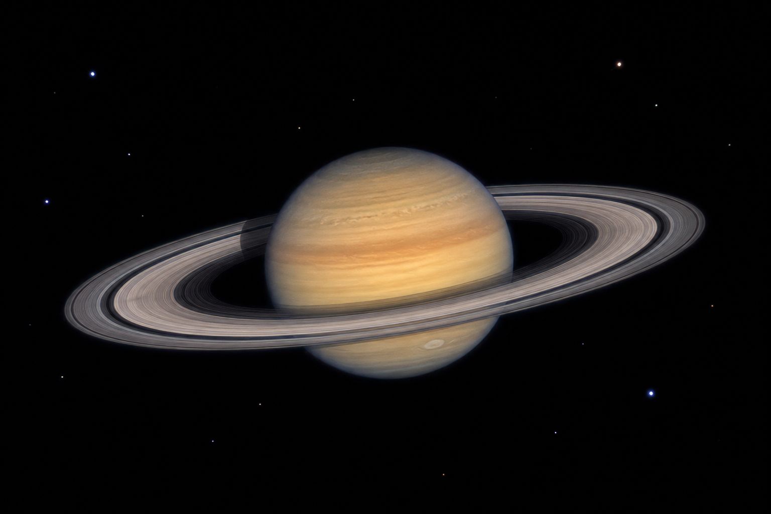 Saturn through a small telescope showing the planet's disk with the rings clearly visible around it